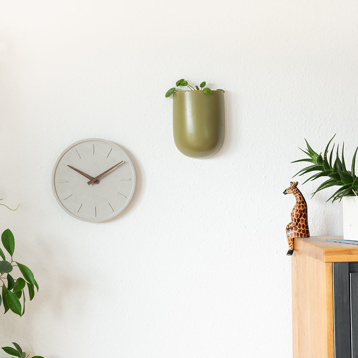 graue nordische Wanduhr aus Beton im Wohnzimmer hängend